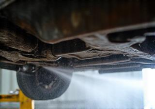 Detailed image showing the undercarriage of a car being pressure washed - emphasizes rust prevention
